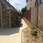 A backyard featuring a concrete patio surrounded by a wooden fence, providing a private outdoor space.